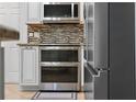 Gourmet kitchen showing stainless steel appliances, including a double oven, and custom cabinetry at 11029 Clay Pit Rd, Tampa, FL 33610