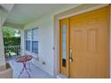 Inviting front porch with seating area and a bright yellow front door with glass panels at 11415 Bright Star Ln, Riverview, FL 33569