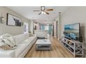 Open-concept living room with modern décor and hardwood floors, seamlessly flowing into the kitchen at 11708 Crest Creek Dr, Riverview, FL 33569