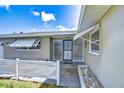 Welcoming front entryway with a decorative security door and awning, enhanced by a charming white picket fence at 12033 82Nd Ave, Seminole, FL 33772