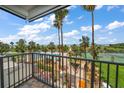 Balcony view of pool, tennis courts, palm trees, blue skies, and manicured lawns at 1230 Gulf Blvd # 304, Clearwater, FL 33767