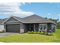 Charming one-story home with a paved driveway, manicured lawn, and a two-car garage in a modern color scheme at 12937 Ogden Glade Rd, Dade City, FL 33525