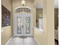 Inviting foyer with tile flooring, a decorative front door, and neutral paint at 17818 Arbor Greene Dr, Tampa, FL 33647