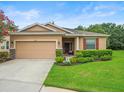 Inviting one-story house with a two-car garage and beautiful landscaping at 27546 Stonecreek Way, Wesley Chapel, FL 33544
