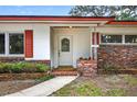 Inviting front entrance with decorative glass door, brick accents, and a 'Welcome' mat at 327 Sunnyside Rd, Temple Terrace, FL 33617