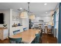 Open dining area featuring hardwood floors, a wooden table, and white cabinetry at 4002 W Watrous Ave, Tampa, FL 33629