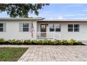 Inviting front porch with brick walkway, white railings, and lush landscaping at 4002 W Watrous Ave, Tampa, FL 33629