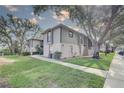 Side view of condo buildings on a sunny day with sidewalks and manicured lawns under mature trees at 4014 Ashford Green Pl # G103, Tampa, FL 33613