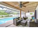Inviting covered patio with comfortable seating area, ceiling fans, overlooking a sparkling swimming pool at 4211 Elba Pl, Valrico, FL 33596