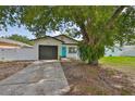 Charming single-story home with a gray garage door and bright turquoise front door at 4489 57Th N Ave, St Petersburg, FL 33714