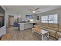 Open-concept living area with a large tan couch, ceiling fan, and wood-look floors at 4489 57Th N Ave, St Petersburg, FL 33714