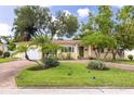 Charming single-story home featuring a brick driveway, lush landscaping, and a vibrant green front door at 5262 25Th N Ave, St Petersburg, FL 33710