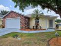 Charming single-story home showcasing a brick facade, manicured landscaping, and a two-car garage at 5755 Yorkshire Dr, Zephyrhills, FL 33542