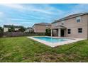 Backyard view featuring a sparkling pool, well-kept lawn, and covered patio at 5916 Tulip Flower Dr, Riverview, FL 33578