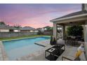 Inviting backyard features a pool, patio with seating, dining area, and lush landscaping, perfect for outdoor living and entertaining at 5916 Tulip Flower Dr, Riverview, FL 33578