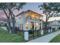 Two-story house boasts a large front porch and second story balcony, as well as a black iron fence at 608 Grove N St, St Petersburg, FL 33701