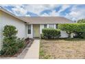Close up of front exterior with a charming yellow front door and well maintained landscaping at 6908 Mesa Verde St, Port Richey, FL 34668