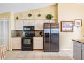 Spacious kitchen with stainless steel refrigerator, black appliances, granite countertops, and ample cabinet space at 6908 Mesa Verde St, Port Richey, FL 34668