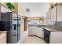 Bright kitchen with stainless steel refrigerator, granite countertops, and tile flooring at 6908 Mesa Verde St, Port Richey, FL 34668