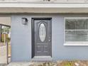 Close up of gray home exterior with ornate front door and a window on either side at 705 3Rd Ne Ave, Largo, FL 33770