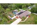 Aerial view showcases a home with pool, solar panels, and fenced yard at 807 E Chapman Rd, Lutz, FL 33549