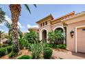 Inviting home entrance with lush landscaping, an arched entryway, and beautiful exterior lighting at 1012 Tuscany Dr, Trinity, FL 34655