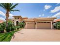 Beautiful Mediterranean home featuring a two-car garage, manicured landscaping, and a brick-paved driveway at 1012 Tuscany Dr, Trinity, FL 34655