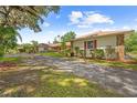Exterior showcases the side view of a home with landscaped beds and a long, private driveway at 10193 Wallien Dr, Brooksville, FL 34601
