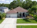 Stunning aerial view of a home with lush landscaping, mature trees, three-car garage and well-kept lawn at 12918 Tar Flower Dr., Tampa, FL 33626
