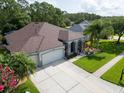 Beautiful aerial shot of a home with three-car garage, mature landscaping and well-maintained lawn at 12918 Tar Flower Dr., Tampa, FL 33626