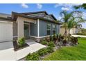 Inviting home exterior with a well-manicured lawn, stone accents, and a charming entryway with beautiful shrubbery at 13235 Palmerston Rd, Riverview, FL 33579
