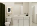 Well-lit bathroom featuring a white vanity, decorative plants, and a framed print against a neutral wall at 13539 White Gold Run, Parrish, FL 34219