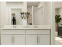 Bright bathroom featuring a double sink vanity with modern faucets and decorative vase with plant sprigs at 13539 White Gold Run, Parrish, FL 34219