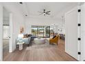 Staged living room with hardwood floors, a ceiling fan and sliding glass doors to the lanai at 15218 Appleton Blvd, Port Charlotte, FL 33981