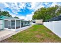 Spacious backyard featuring a screened-in lanai and a privacy fence, perfect for outdoor enjoyment at 17824 Morninghigh Dr, Lutz, FL 33549