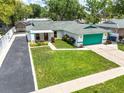 An aerial front view showcasing a well-manicured lawn and a charming single-story home at 17824 Morninghigh Dr, Lutz, FL 33549