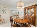 A dining area features a round table, chandelier, cabinet and a peek into other rooms at 214 Caryl Way, Oldsmar, FL 34677