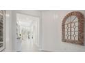 Bright hallway with white walls, tile flooring, and decorative mirror accent at 2238 Stratten Dr, Zephyrhills, FL 33541