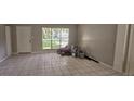 Bright living room featuring tile flooring, a large window, and a white front door at 2503 Elm St, Seffner, FL 33584