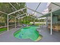 A refreshing screened-in pool area featuring unique tile accents, a swim-up bar, and lush greenery at 3633 Springville Dr, Valrico, FL 33596