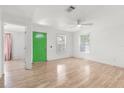Bright living room featuring wood floors, ceiling fan and a green door at 3953 10Th S Ave, St Petersburg, FL 33711