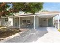 Charming single-story home featuring a covered carport, lush tree, and neutral-colored exterior paint at 4318 Mesa Dr, New Port Richey, FL 34653