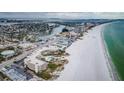 Breathtaking aerial view showcasing the condo complex, sandy beach and waterfront community at 4450 Gulf Blvd # 110, St Pete Beach, FL 33706