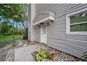 Side entrance to home with stepping stones, landscaping, and gray siding at 6263 Oak Cluster Cir, Tampa, FL 33634