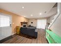 A cozy living room with fireplace, gray sofa, wood floors and natural light at 6263 Oak Cluster Cir, Tampa, FL 33634