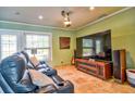 Cozy living room boasts a plush leather sofa, a large screen TV, and travertine tile flooring at 6912 14Th N St # 6912, St Petersburg, FL 33702