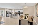 Open-concept kitchen and dining area with white cabinets, stainless appliances, and granite countertops at 7017 Gomez Rocks Ct, Sun City Center, FL 33573