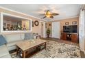 Comfortable living room with a ceiling fan, view to the kitchen, hardwood flooring and plush carpet at 7676 18Th St N, St Petersburg, FL 33702