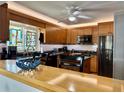Charming kitchen with wooden cabinets, granite countertops, and an eat-in bar area at 100 Bluff View Dr # 114C, Belleair Bluffs, FL 33770