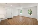 Bright living room with wood flooring, a ceiling fan, and natural light from the windows at 10219 Huntley St, New Port Richey, FL 34654
